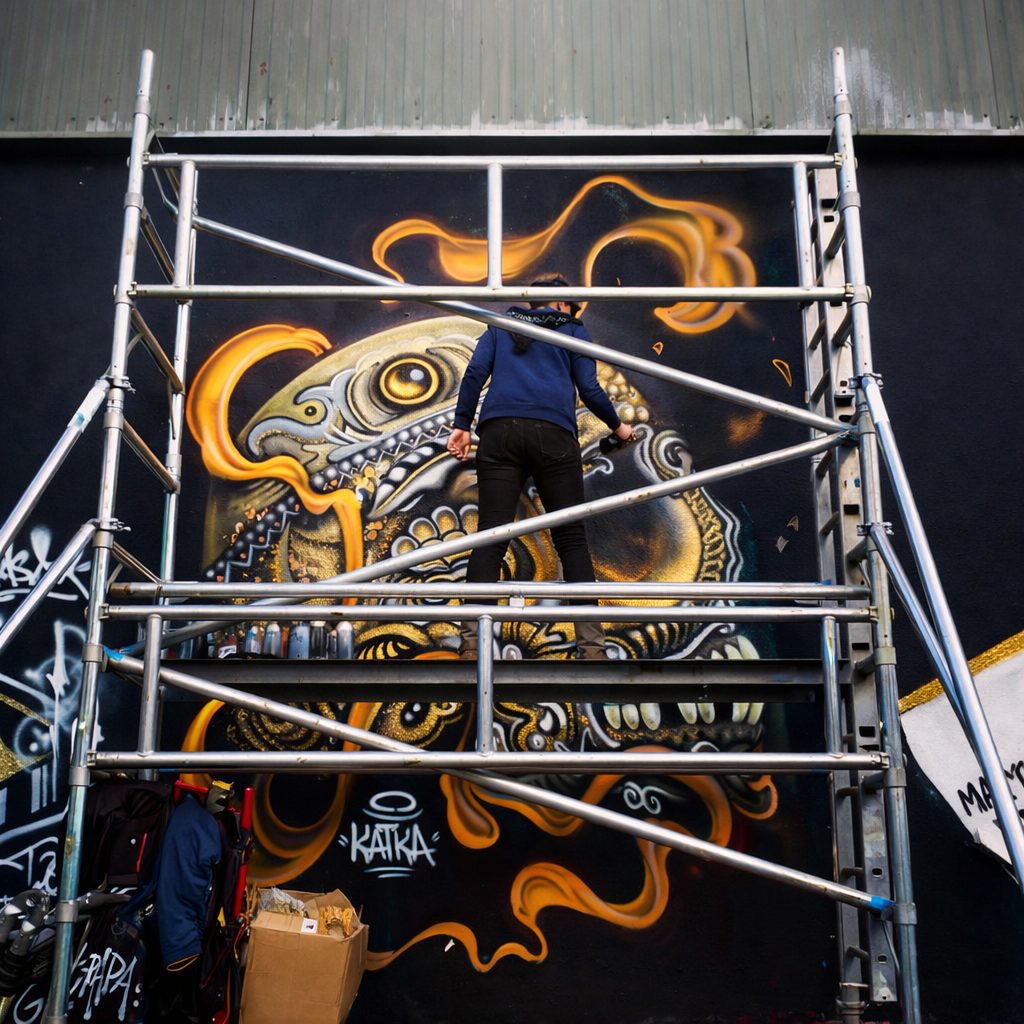 Artiste street art en train de réaliser une fresque à Belfort